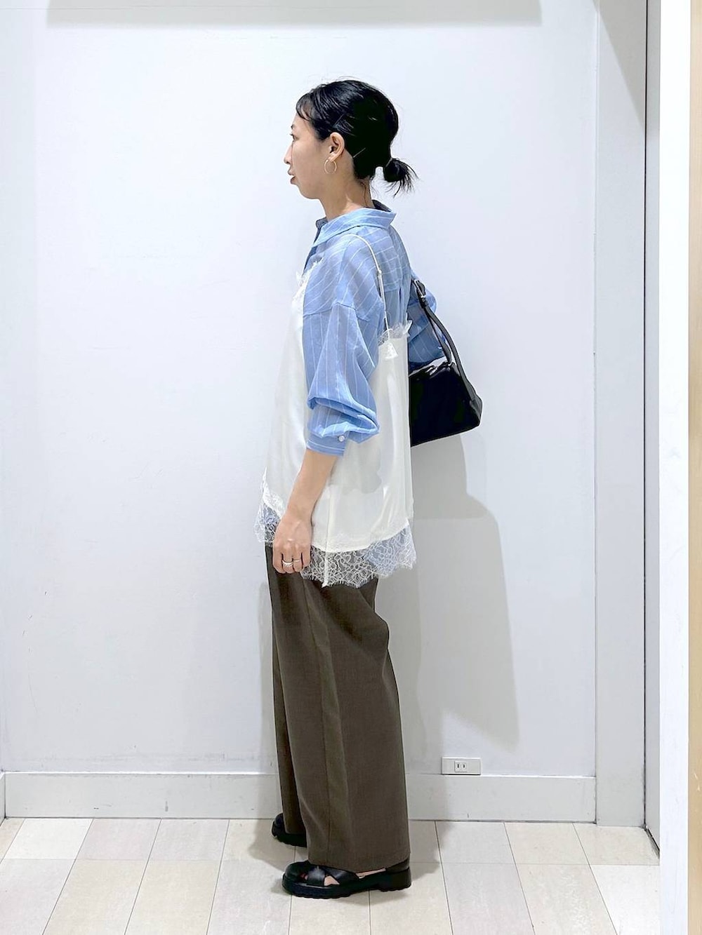 ブラウン系のその他パンツ、ブラック系のショルダーバッグ、ブルー系のシャツ/ブラウスを着用したレディースの春コーディネートの2枚目の写真