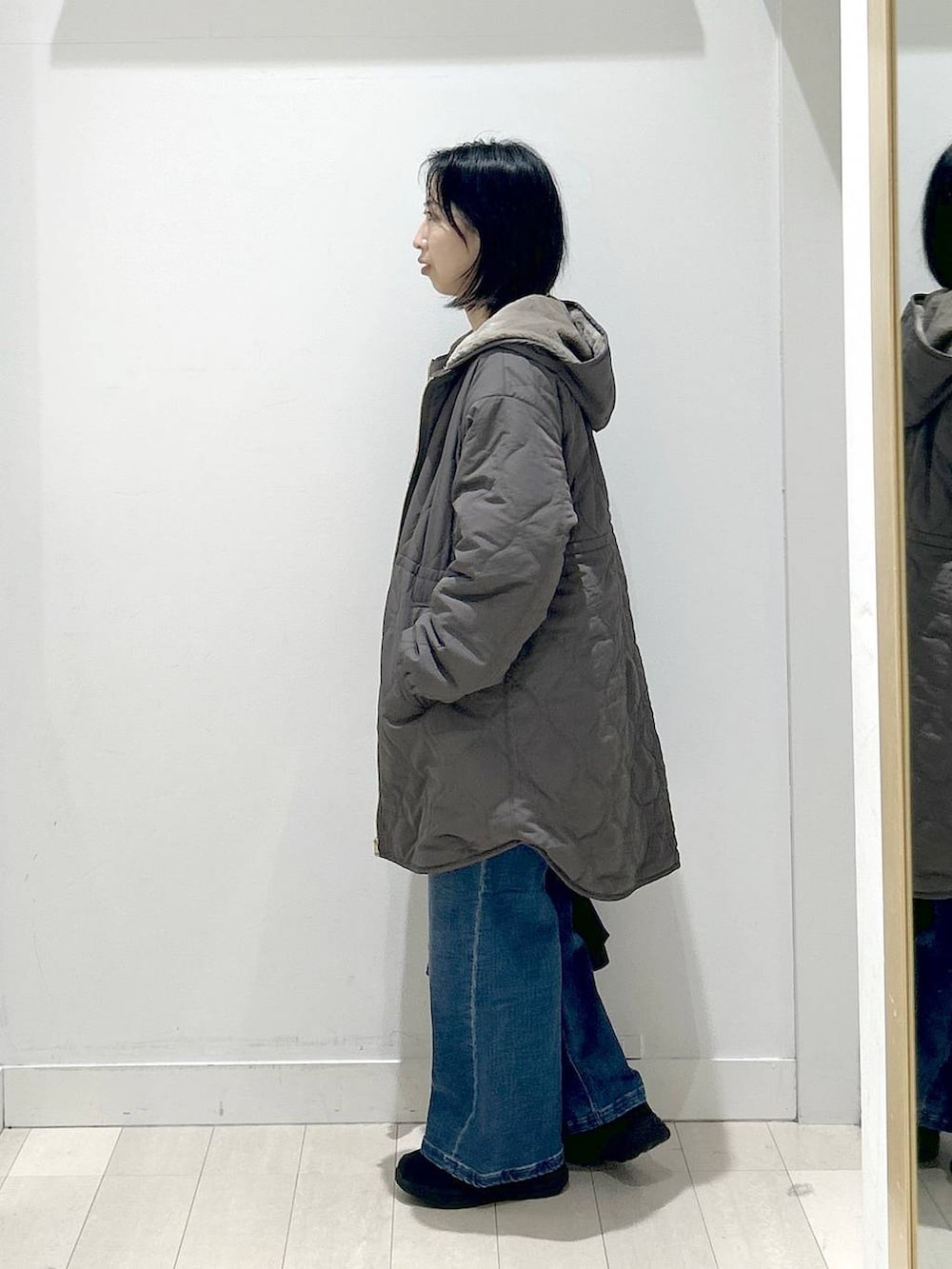 ブラック系のショルダーバッグ、ブラウン系のブルゾン、ホワイト系のTシャツ/カットソーを着用したレディースの冬コーディネートの4枚目の写真