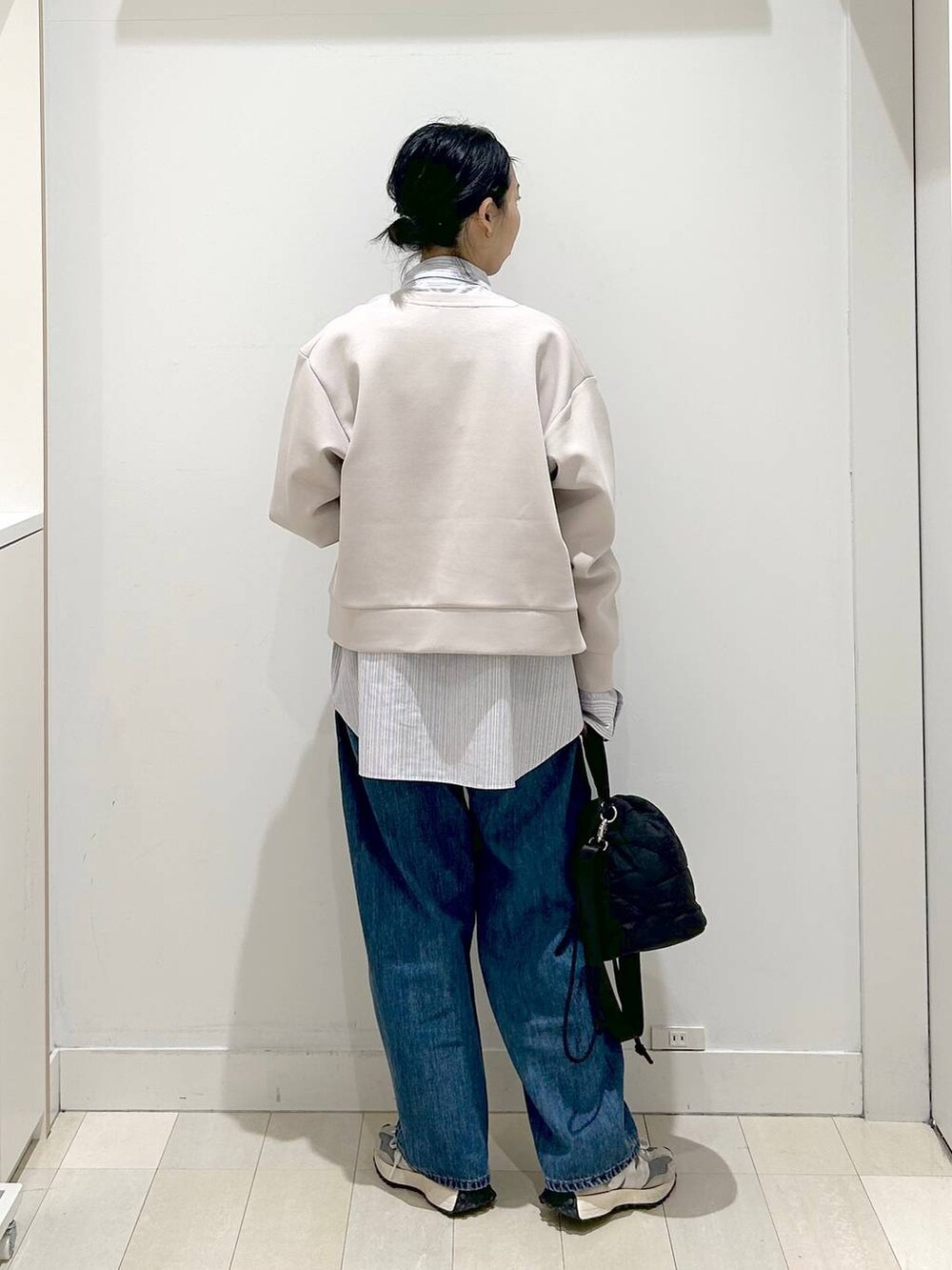 ブラック系のハンドバッグ、ブルー系のデニムパンツ、ピンク系のカーディガン/ボレロを着用したレディースの春コーディネートの3枚目の写真