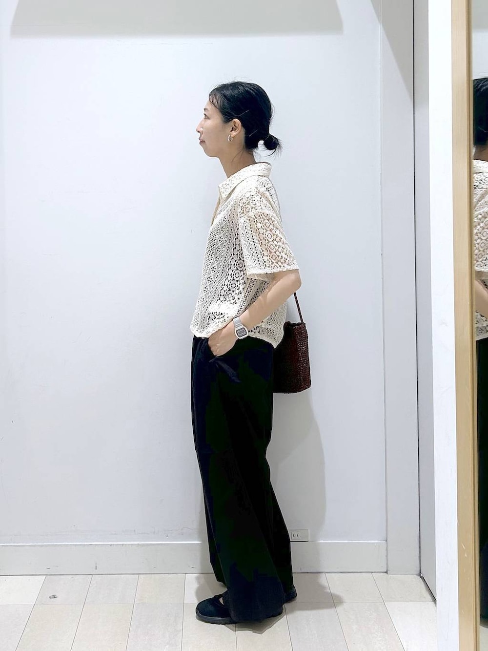 ブラック系のその他パンツ、ブラウン系のクラッチバッグ、ブラック系のスニーカーを着用したレディースの春コーディネートの2枚目の写真