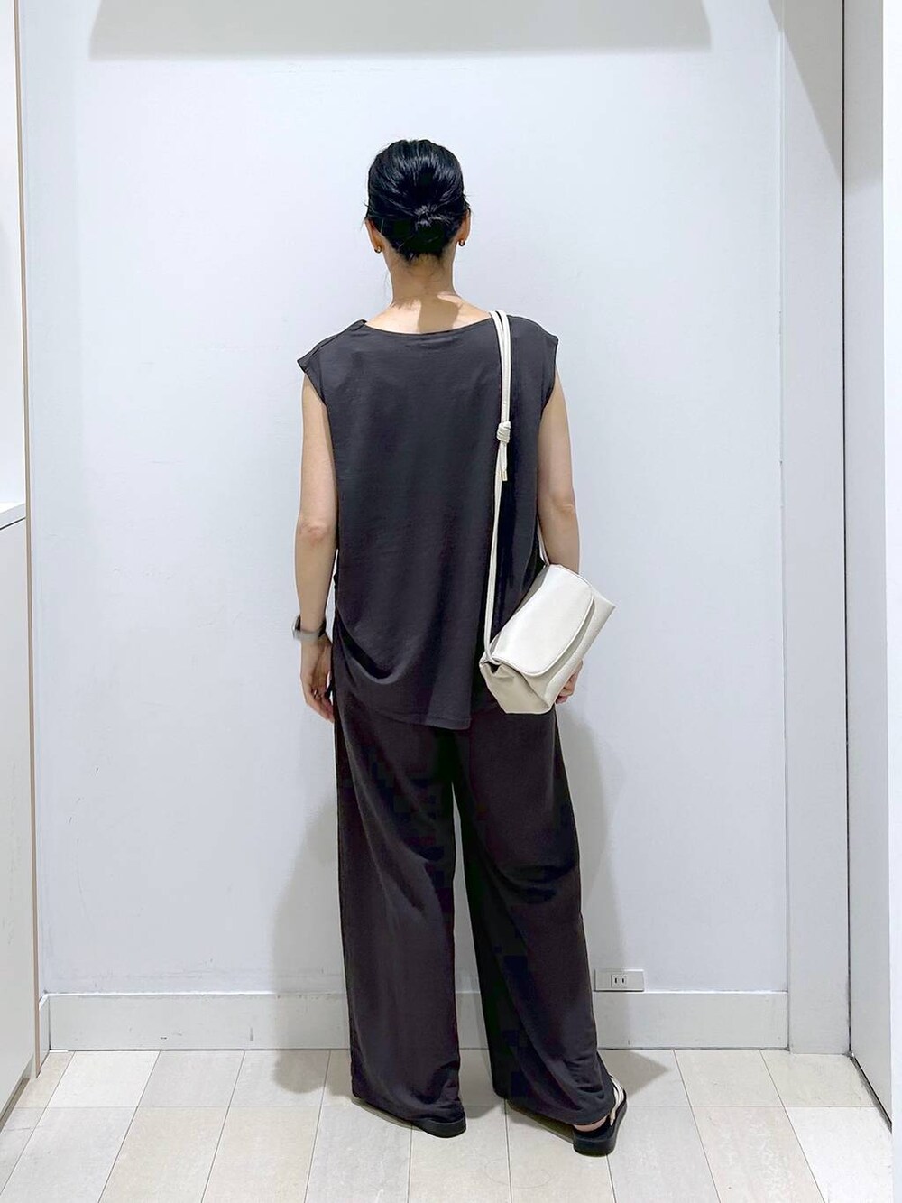 ベージュ系のショルダーバッグ、ブラック系のTシャツ/カットソー、ベージュ系のサンダルを着用したレディースの夏コーディネートの3枚目の写真