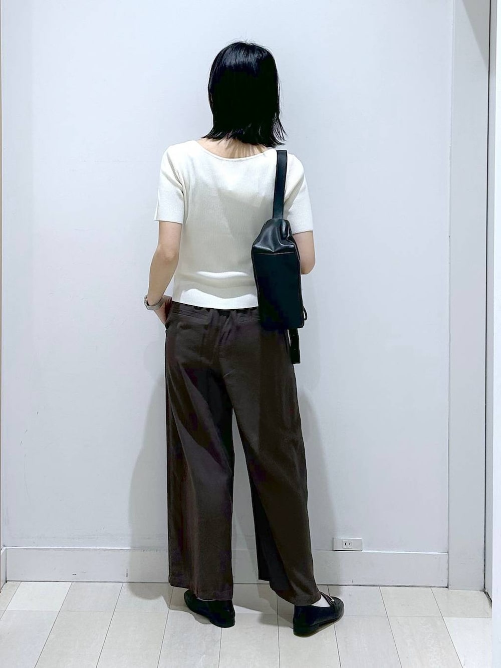 ブラック系のローファー、ブラウン系のその他パンツ、ブラック系のショルダーバッグを着用したレディースの春コーディネートの3枚目の写真