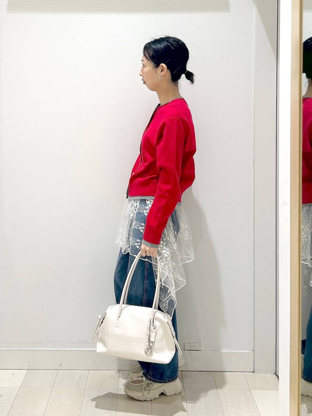 ホワイト系のボストンバッグ、ブルー系のデニムパンツ、ホワイト系のその他トップスを着用したレディースの春コーディネートの2枚目の写真