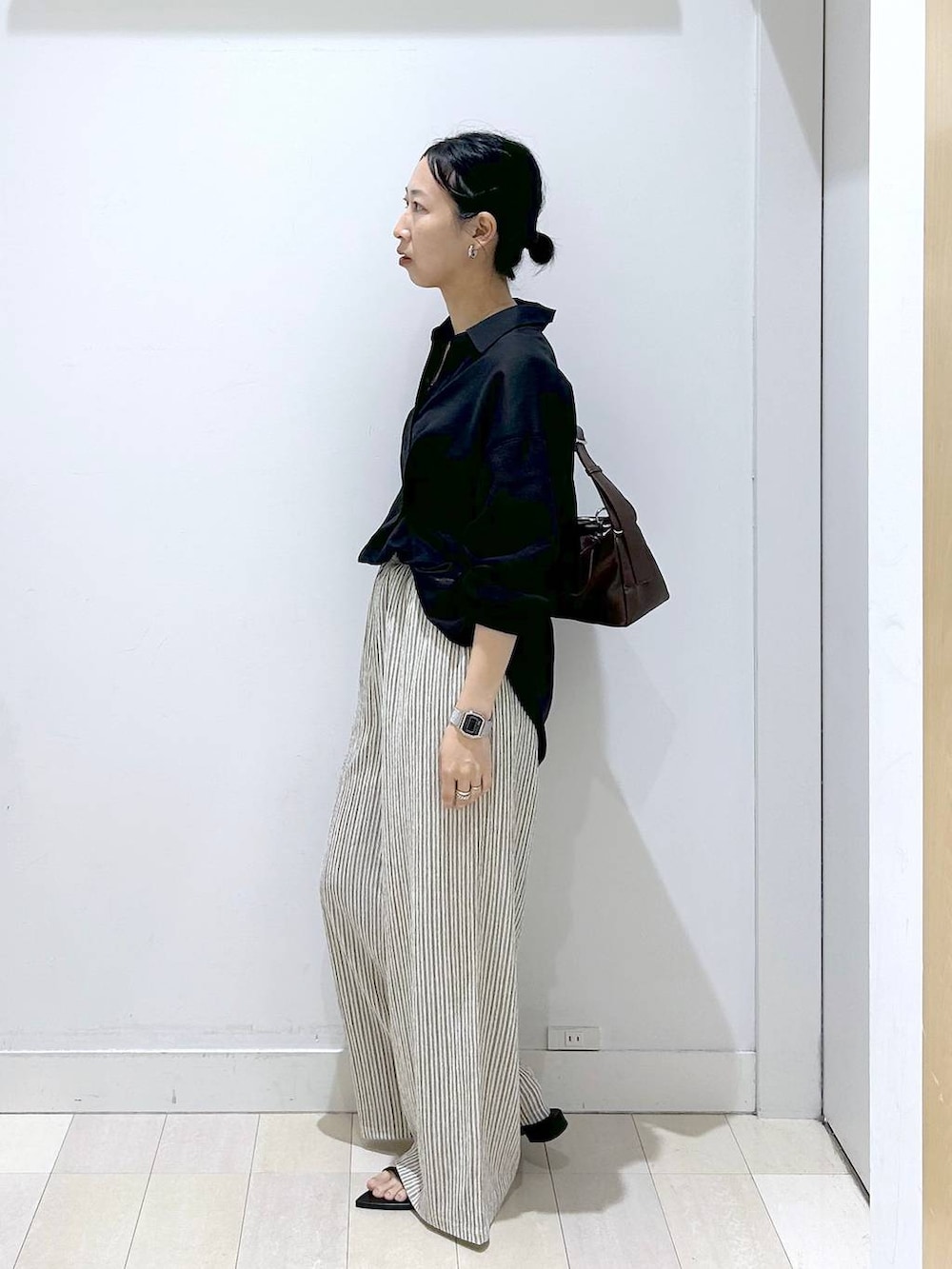 ブラック系のシャツ/ブラウス、ブラウン系のショルダーバッグ、ホワイト系のその他パンツを着用したレディースの夏コーディネートの2枚目の写真
