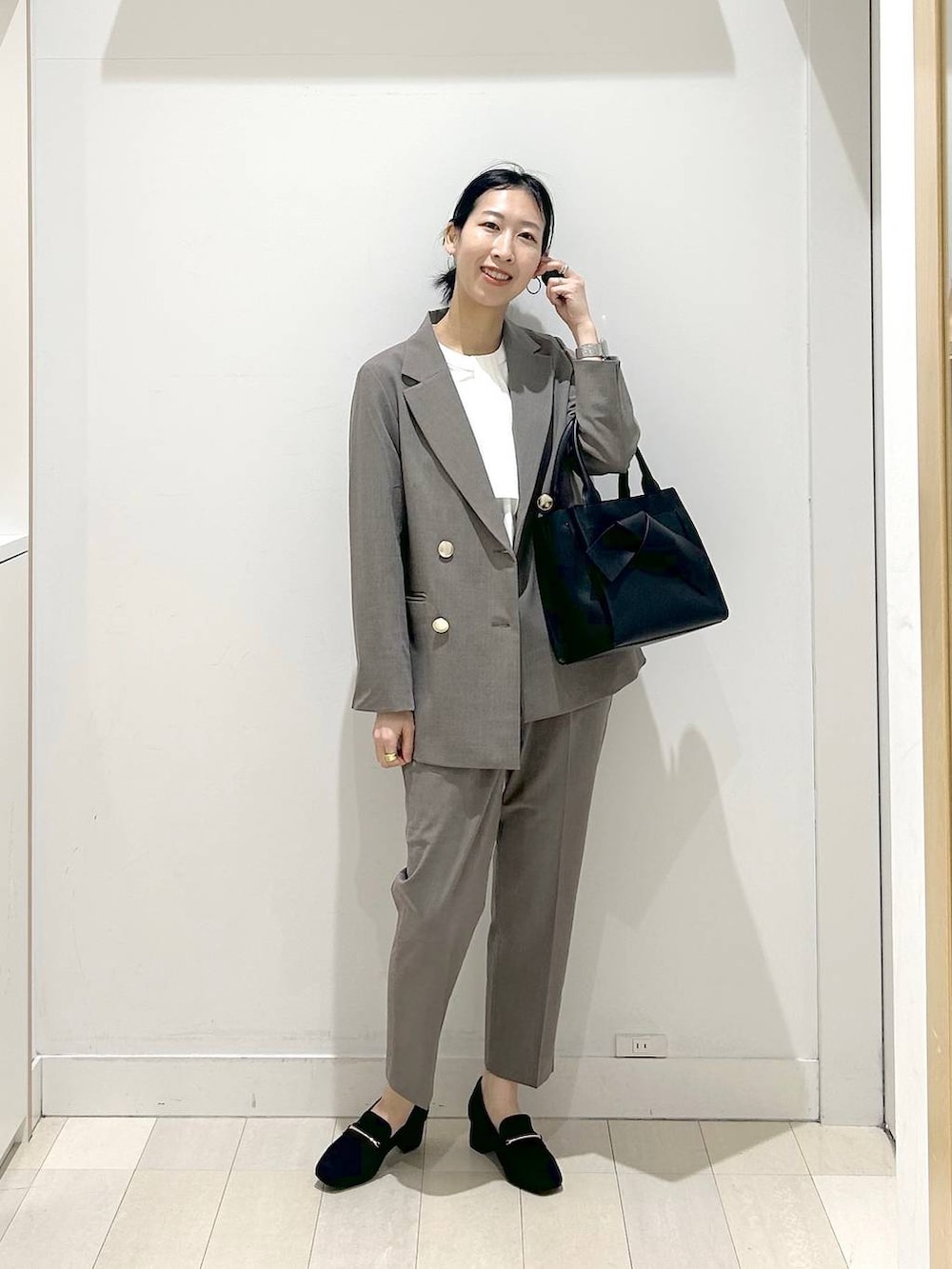 ブラック系のローファー、ブラウン系のスラックス、ホワイト系のシャツ/ブラウスを着用したレディースの春コーディネートの5枚目の写真