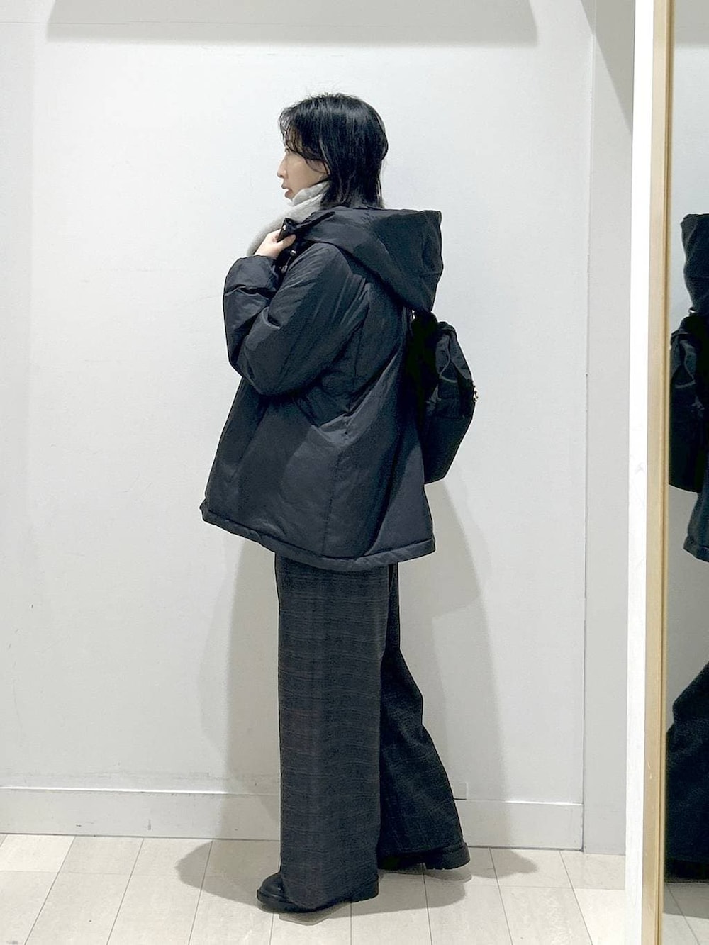 ブラック系のショルダーバッグ、ブラック系のダウンジャケット/コート、ブラック系のブーツを着用したレディースの冬コーディネートの4枚目の写真