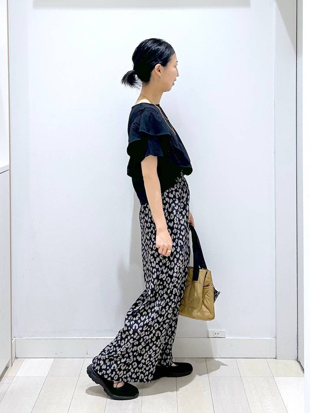ブラウン系のトートバッグ、その他のその他パンツ、ブラック系のスニーカーを着用したレディースの春コーディネートの4枚目の写真