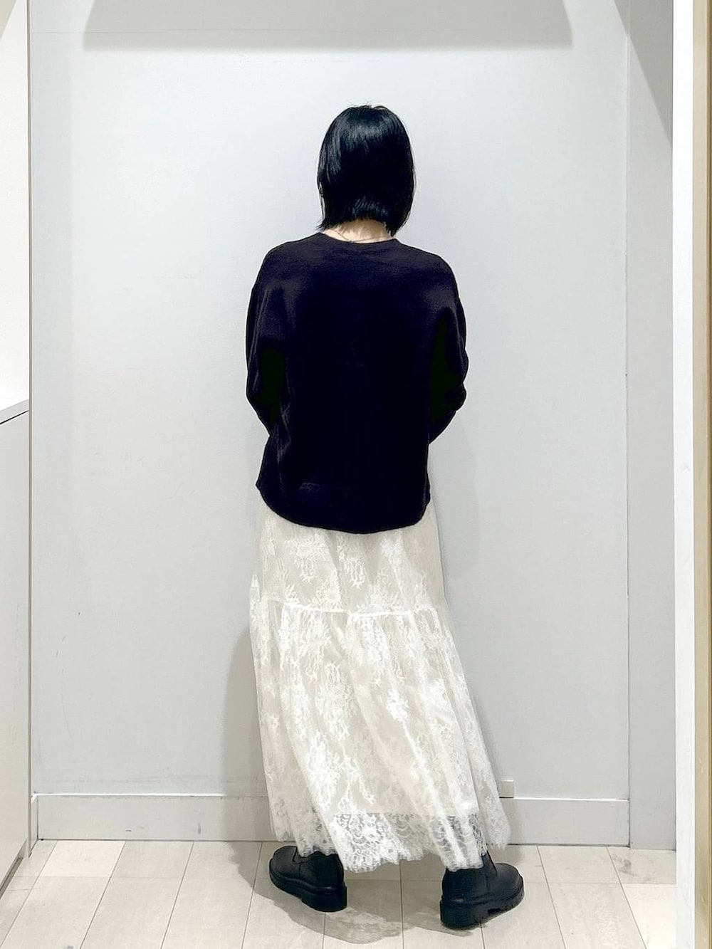 ブラウン系のショルダーバッグ、ブラック系のブーツ、ブラウン系のワンピースを着用したレディースの冬コーディネートの3枚目の写真