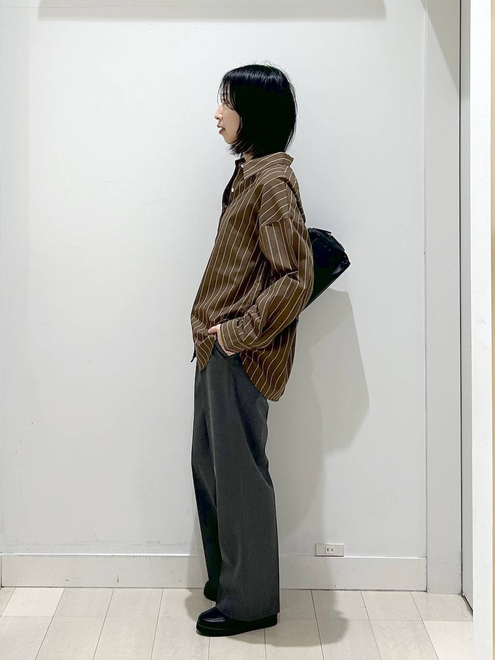 ブラック系のローファー、ブラウン系のシャツ/ブラウス、グレー系のスラックスを着用したレディースの春コーディネートの2枚目の写真