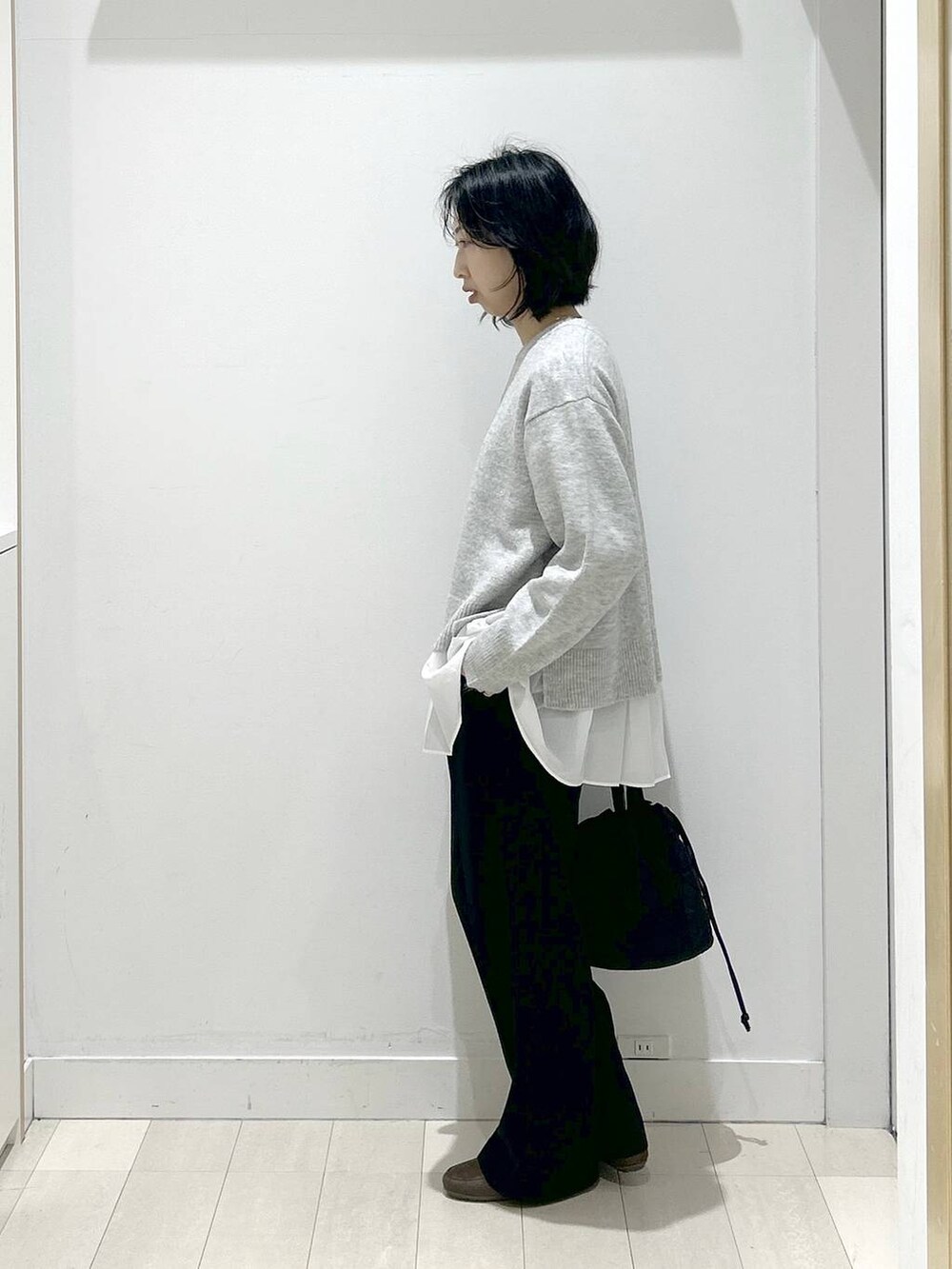 ブラック系のハンドバッグ、シルバー系のニット/セーター、ブラック系のその他パンツを着用したレディースの冬コーディネートの4枚目の写真