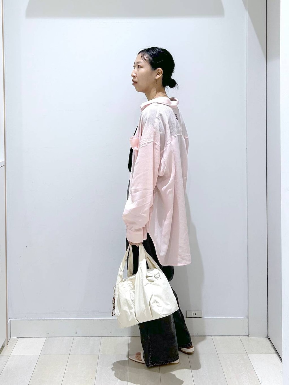 ホワイト系のトートバッグ、ブラック系のデニムパンツ、ブラック系のTシャツ/カットソーを着用したレディースの夏コーディネートの2枚目の写真
