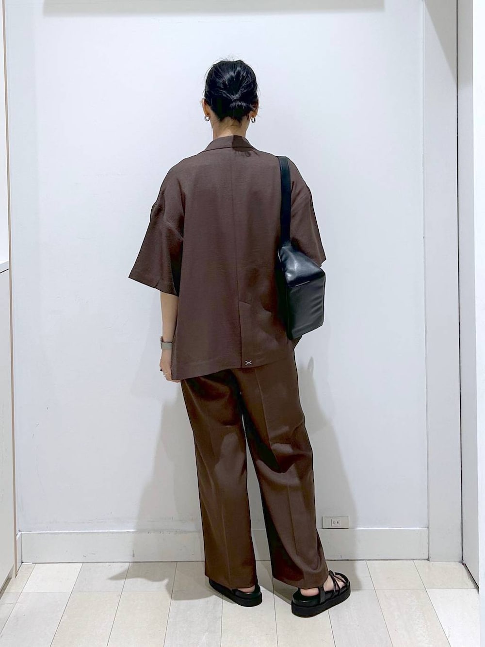 ブラウン系のテーラードジャケット、ブラウン系のその他パンツ、ブラック系のショルダーバッグを着用したレディースの夏コーディネートの3枚目の写真