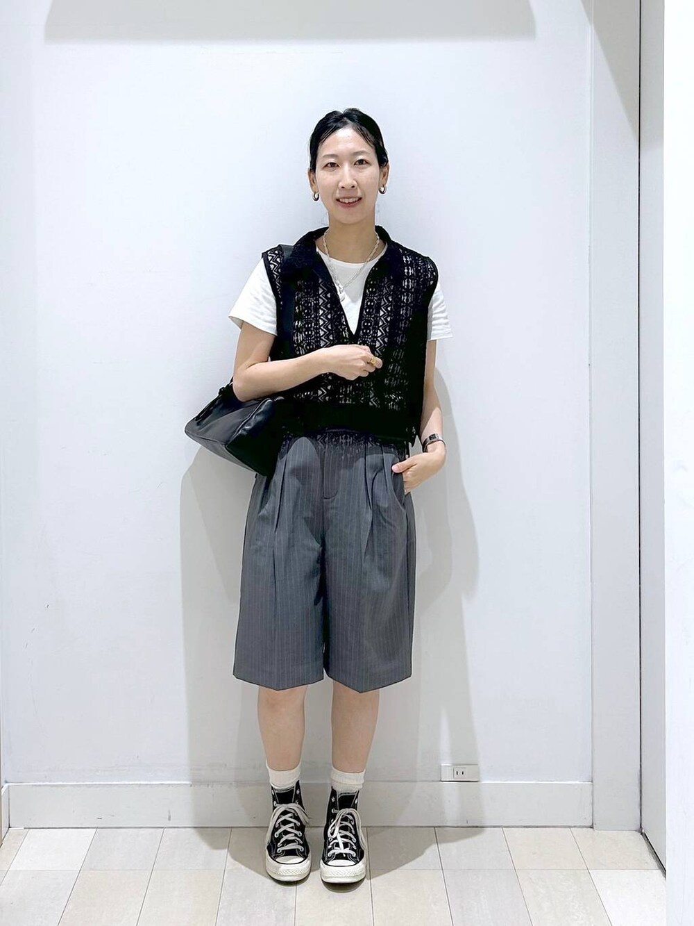 ブラック系のショルダーバッグ、ホワイト系のTシャツ/カットソー、ブラック系のベストを着用したレディースの夏コーディネートの5枚目の写真