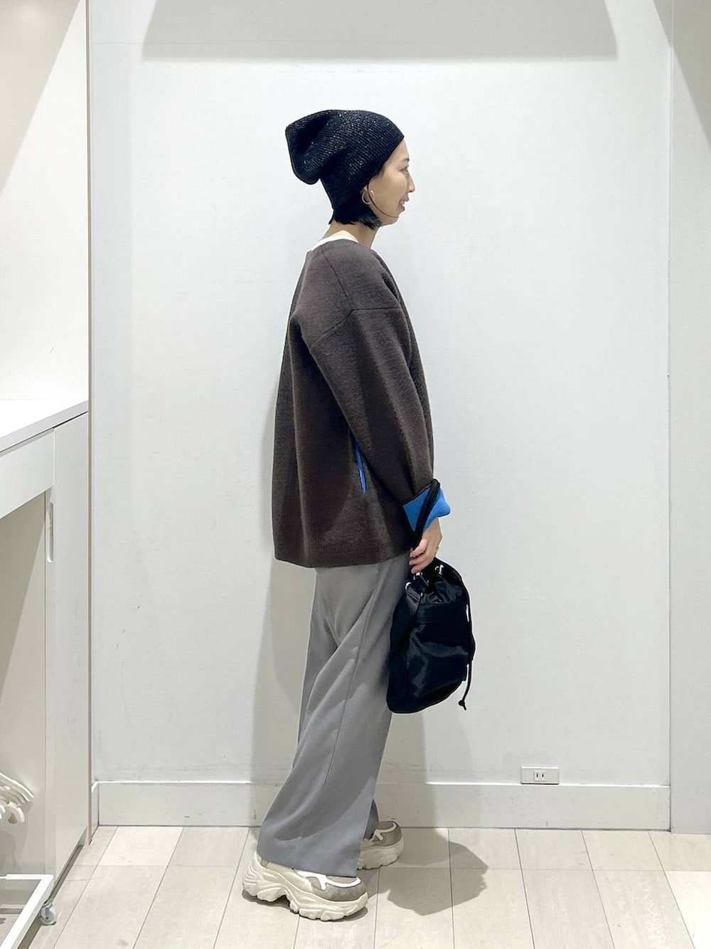 ブラック系のショルダーバッグ、グレー系のその他パンツ、ホワイト系のTシャツ/カットソーを着用したレディースの秋コーディネートの2枚目の写真