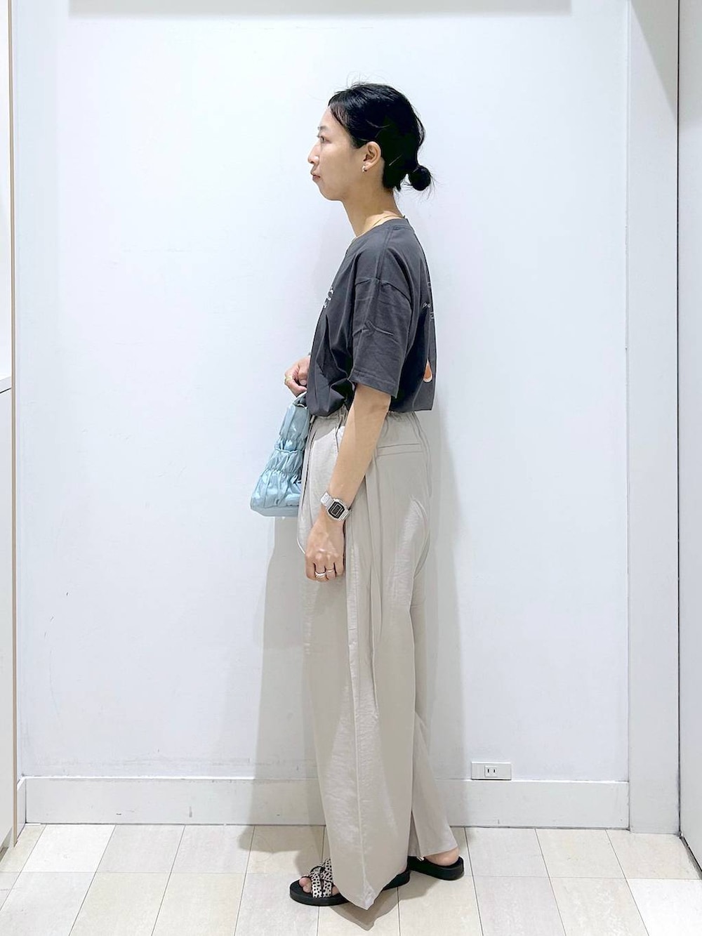 ブルー系のトートバッグ、ベージュ系のその他パンツ、ブラック系のサンダルを着用したレディースの夏コーディネートの3枚目の写真