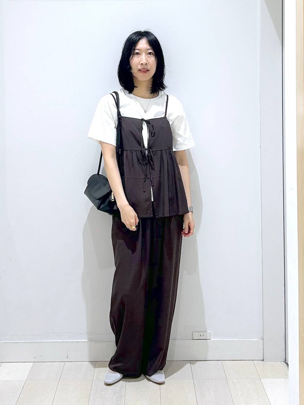 ブラック系のショルダーバッグ、ブラウン系のその他パンツ、ブラック系のTシャツ/カットソーを着用したレディースの春コーディネートの5枚目の写真