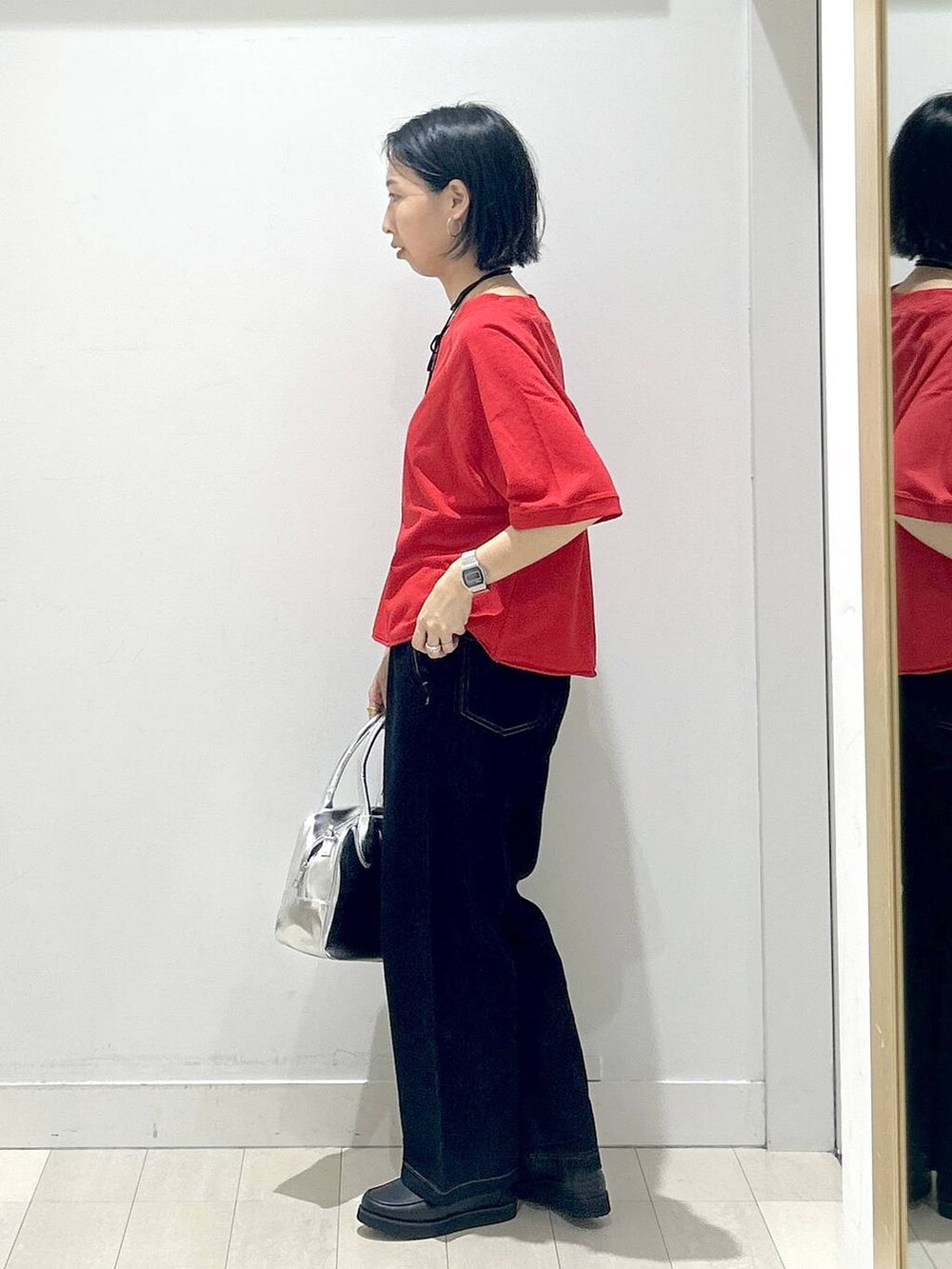 ブラック系のローファー、グレー系のボストンバッグ、ブルー系のデニムパンツを着用したレディースの秋コーディネートの4枚目の写真