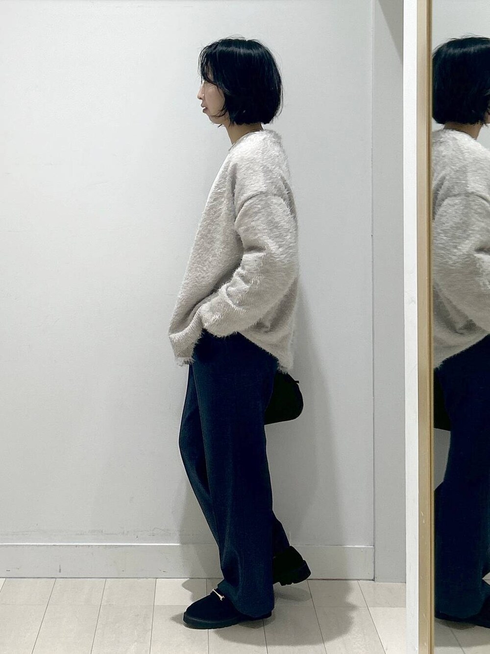 ブラック系のボストンバッグ、ブラック系のローファー、ブルー系のその他パンツを着用したレディースの秋コーディネートの4枚目の写真