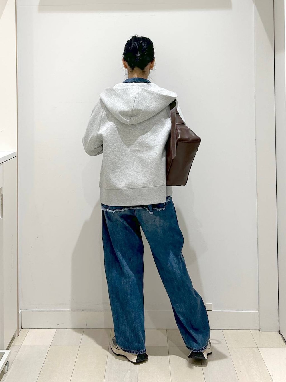 ブラック系のTシャツ/カットソー、グレー系のパーカー、ブルー系のデニムパンツを着用したレディースの冬コーディネートの3枚目の写真