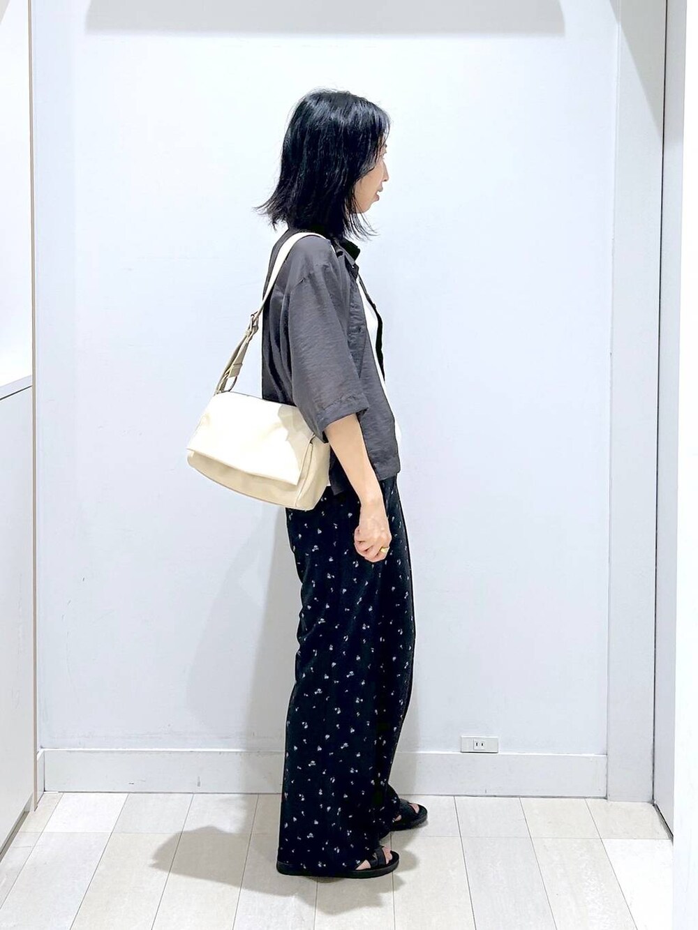 グレー系のシャツ/ブラウス、ホワイト系のタンクトップ、ブラック系のサンダルを着用したレディースの夏コーディネートの4枚目の写真