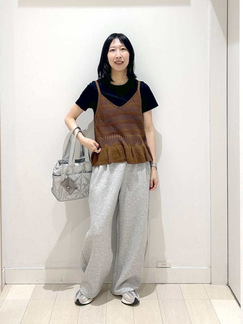 シルバー系のトートバッグ、ブラック系のTシャツ/カットソー、グレー系のその他パンツを着用したレディースの春コーディネートの5枚目の写真