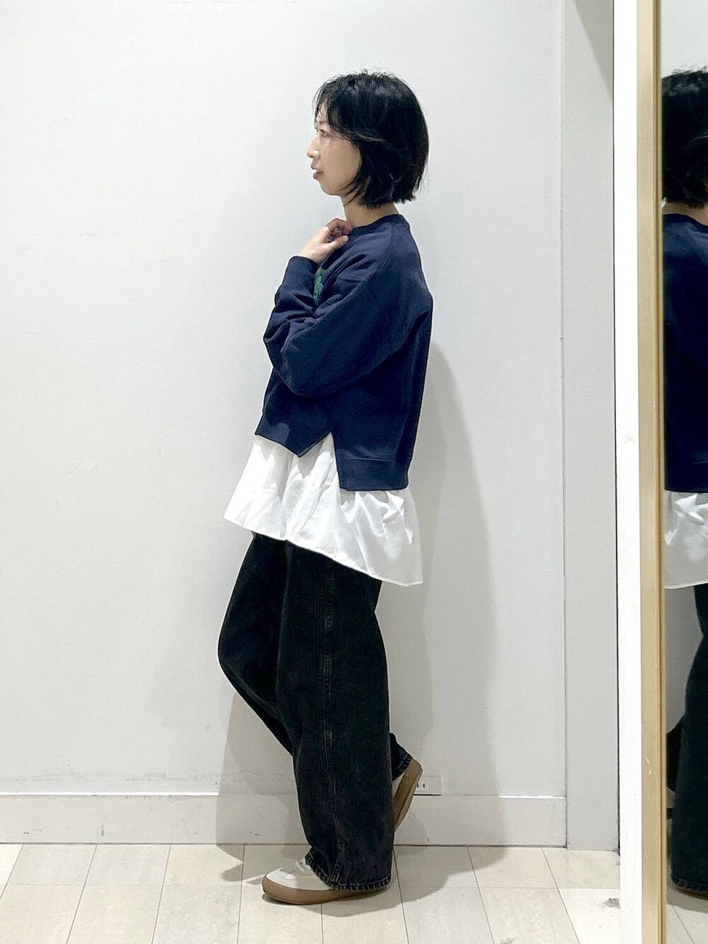 ベージュ系のスニーカー、ブラック系のデニムパンツ、ホワイト系のTシャツ/カットソーを着用したレディースの秋コーディネートの4枚目の写真