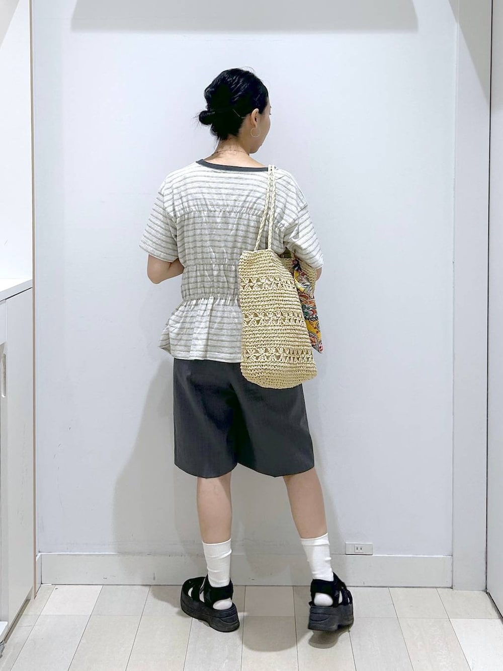 ベージュ系のトートバッグ、グレー系のその他パンツ、ホワイト系のTシャツ/カットソーを着用したレディースの夏コーディネートの3枚目の写真