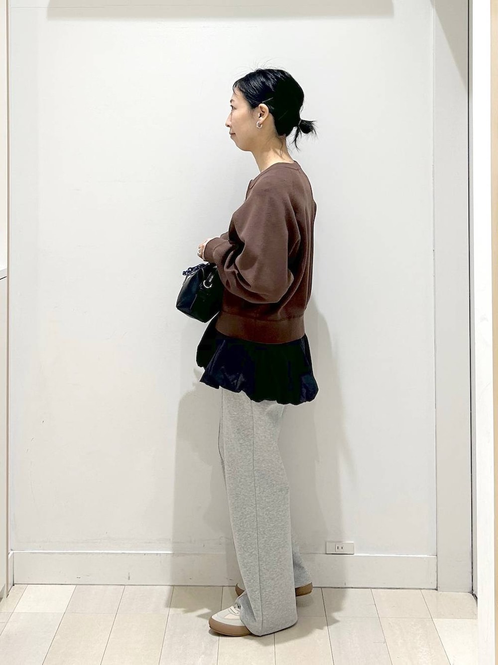 ベージュ系のスニーカー、グレー系のスウェットパンツ、ブラウン系のカーディガン/ボレロを着用したレディースの春コーディネートの2枚目の写真