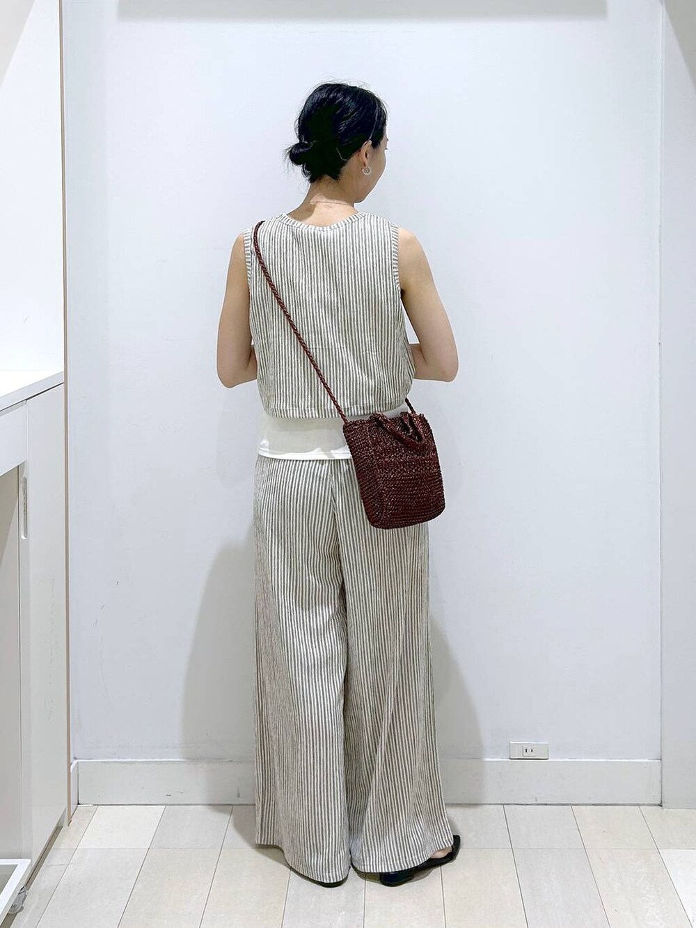 ブラウン系のクラッチバッグ、ホワイト系のその他パンツ、ホワイト系のTシャツ/カットソーを着用したレディースの夏コーディネートの3枚目の写真