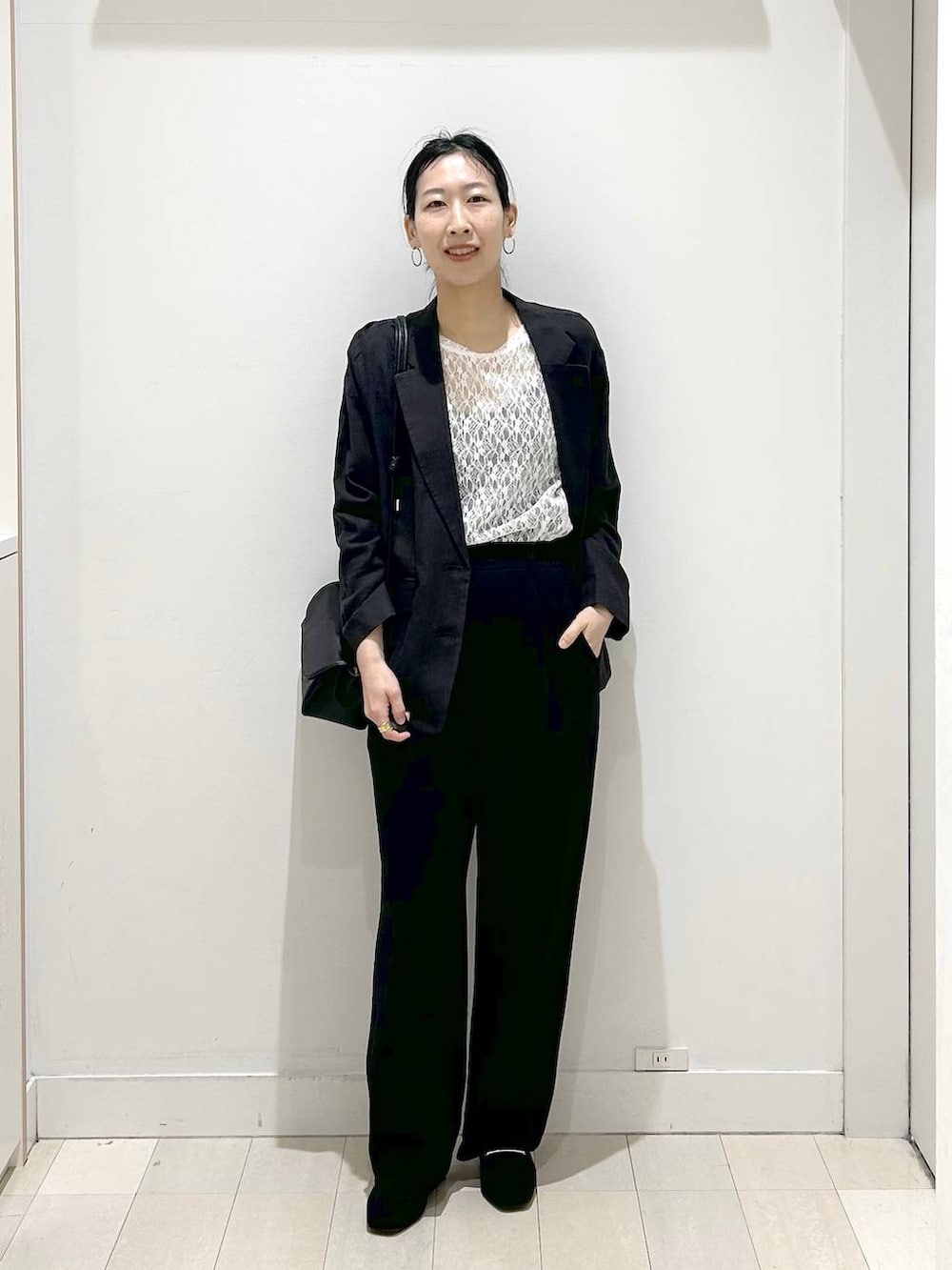ブラック系のローファー、ブラック系のショルダーバッグ、ブラック系のテーラードジャケットを着用したレディースの春コーディネートの5枚目の写真