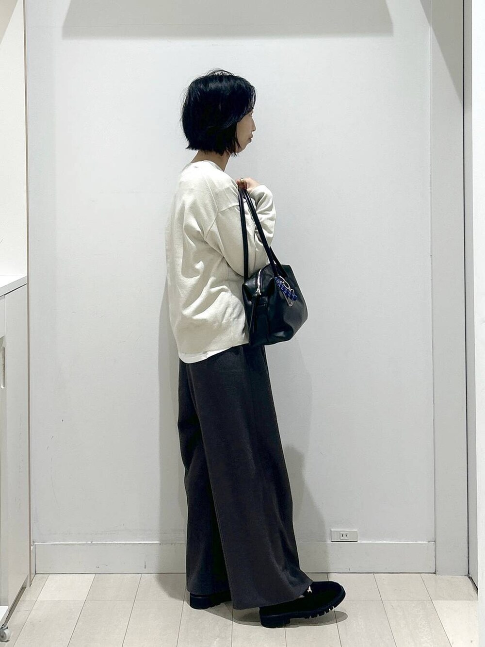 ブラック系のボストンバッグ、ブラック系のローファー、ホワイト系のTシャツ/カットソーを着用したレディースの秋コーディネートの2枚目の写真