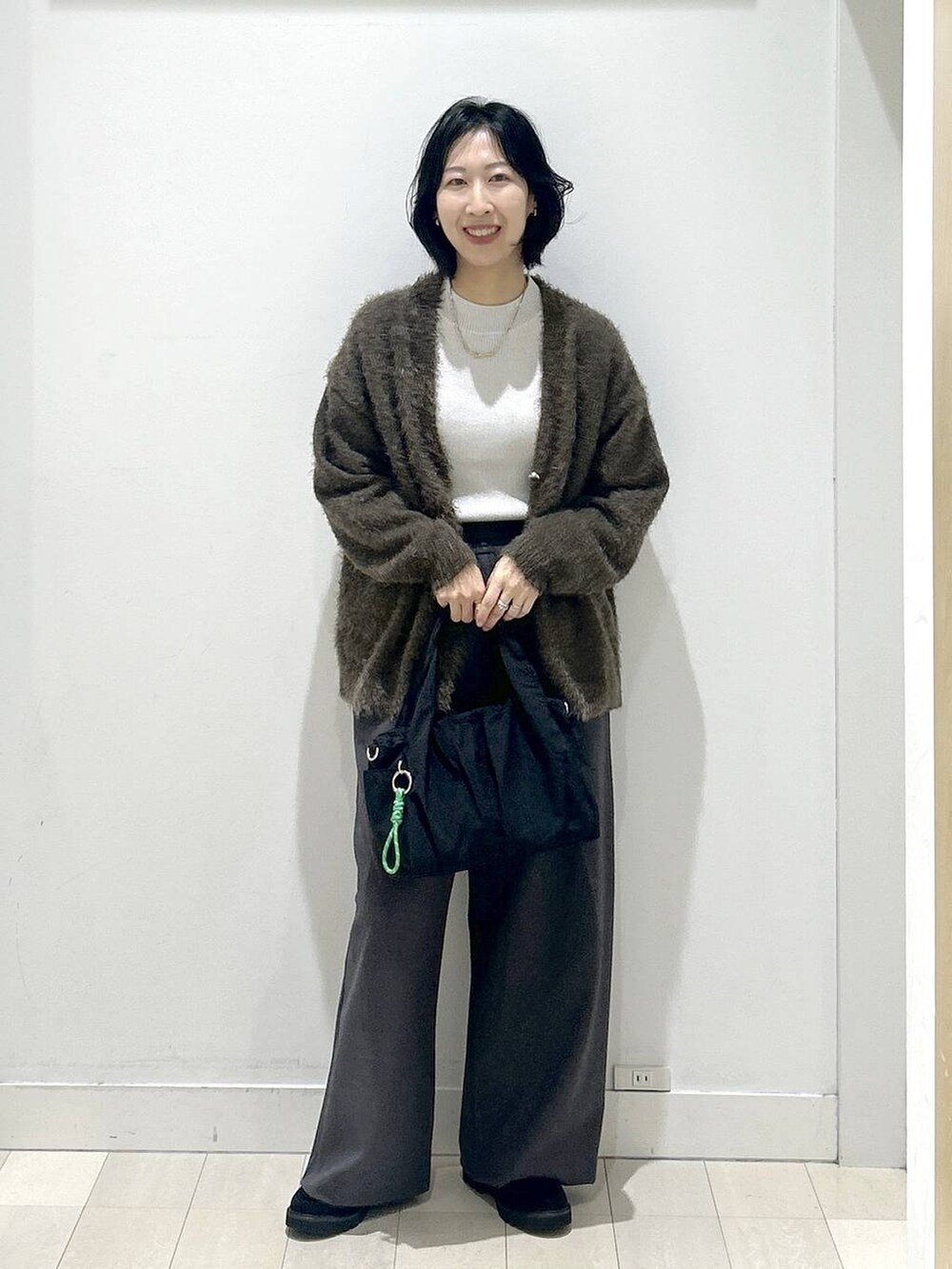 ブラック系のトートバッグ、グレー系のニット/セーター、ブラック系のローファーを着用したレディースの秋コーディネートの5枚目の写真