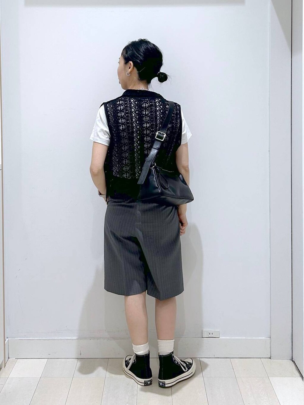 ブラック系のショルダーバッグ、ホワイト系のTシャツ/カットソー、ブラック系のベストを着用したレディースの夏コーディネートの3枚目の写真