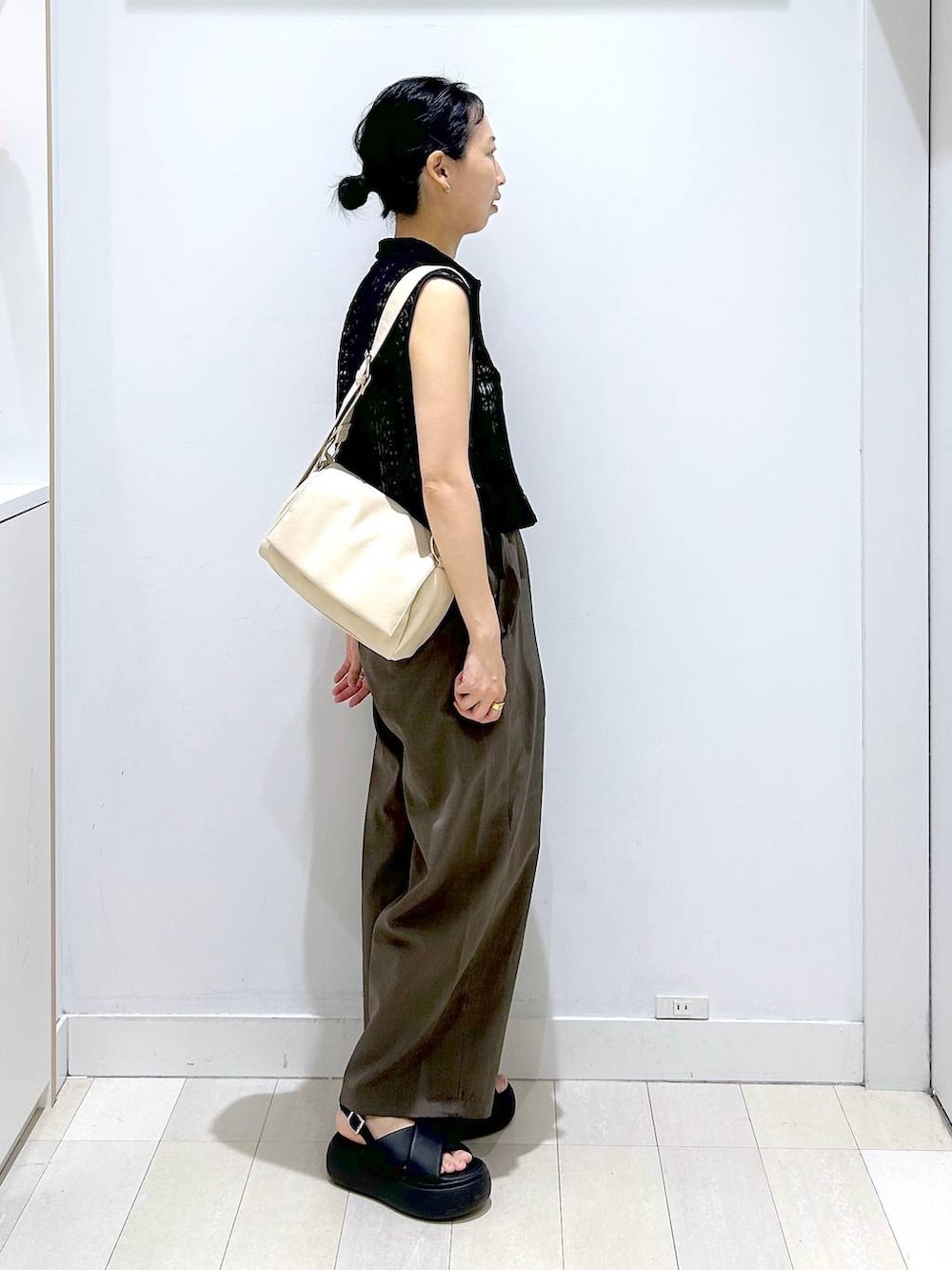 ホワイト系のキャミソール、ブラウン系のその他パンツ、ブラック系のベストを着用したレディースの夏コーディネートの3枚目の写真