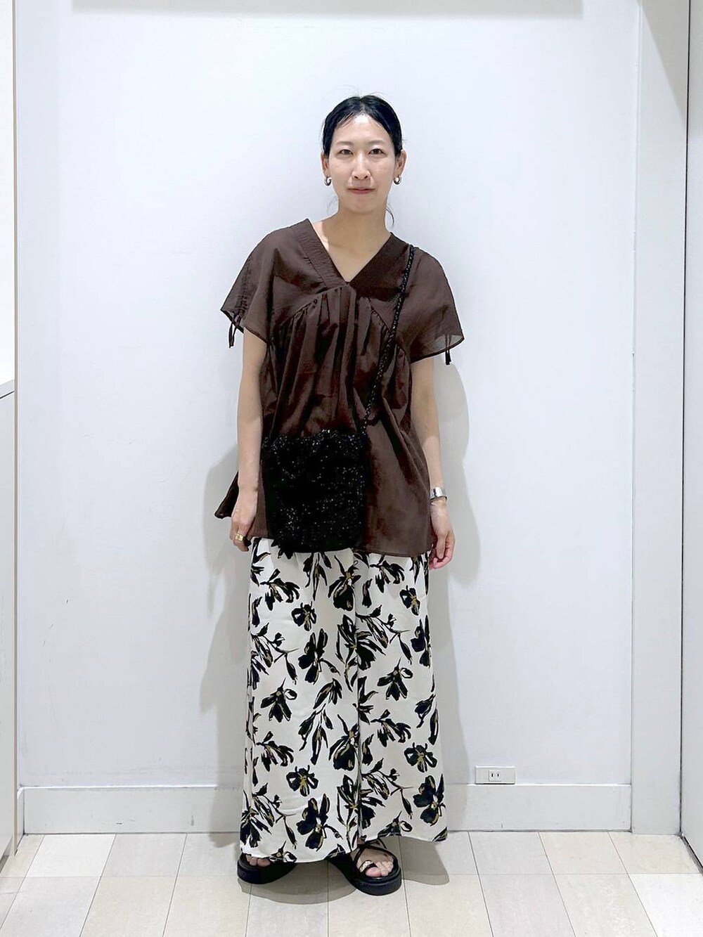 ホワイト系のその他パンツ、ブラウン系のシャツ/ブラウス、ブラック系のクラッチバッグを着用したレディースの春コーディネートの5枚目の写真
