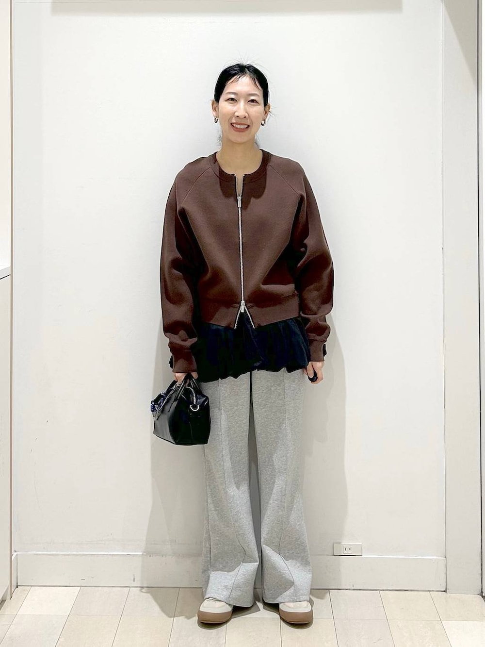 ベージュ系のスニーカー、グレー系のスウェットパンツ、ブラウン系のカーディガン/ボレロを着用したレディースの春コーディネートの5枚目の写真