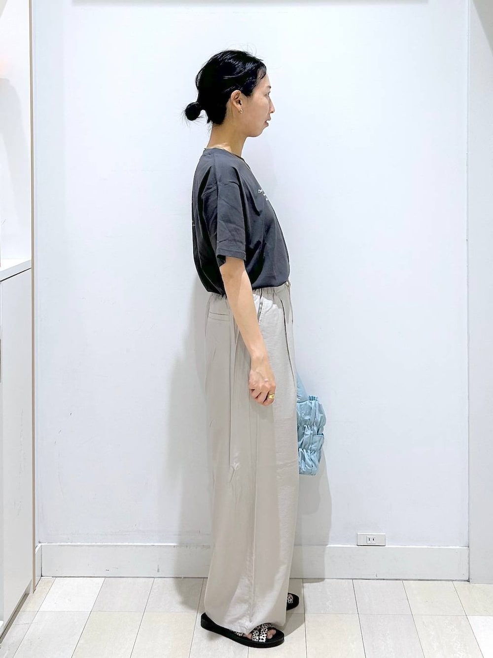 ブルー系のトートバッグ、ベージュ系のその他パンツ、ブラック系のサンダルを着用したレディースの夏コーディネートの4枚目の写真