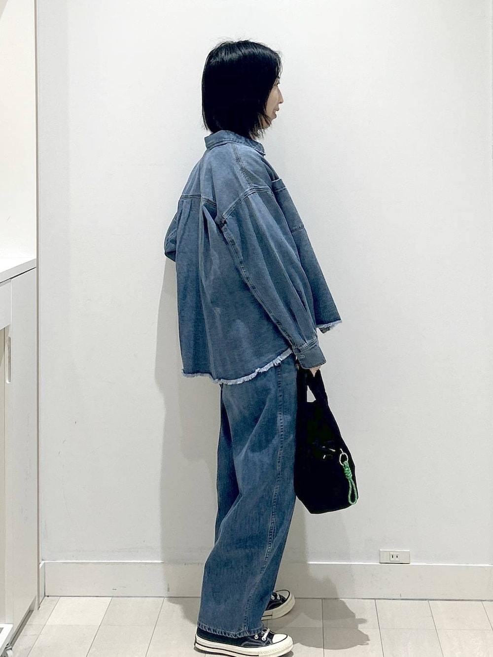 ブラック系のトートバッグ、ブルー系のシャツ/ブラウス、グレー系のニット/セーターを着用したレディースの冬コーディネートの2枚目の写真