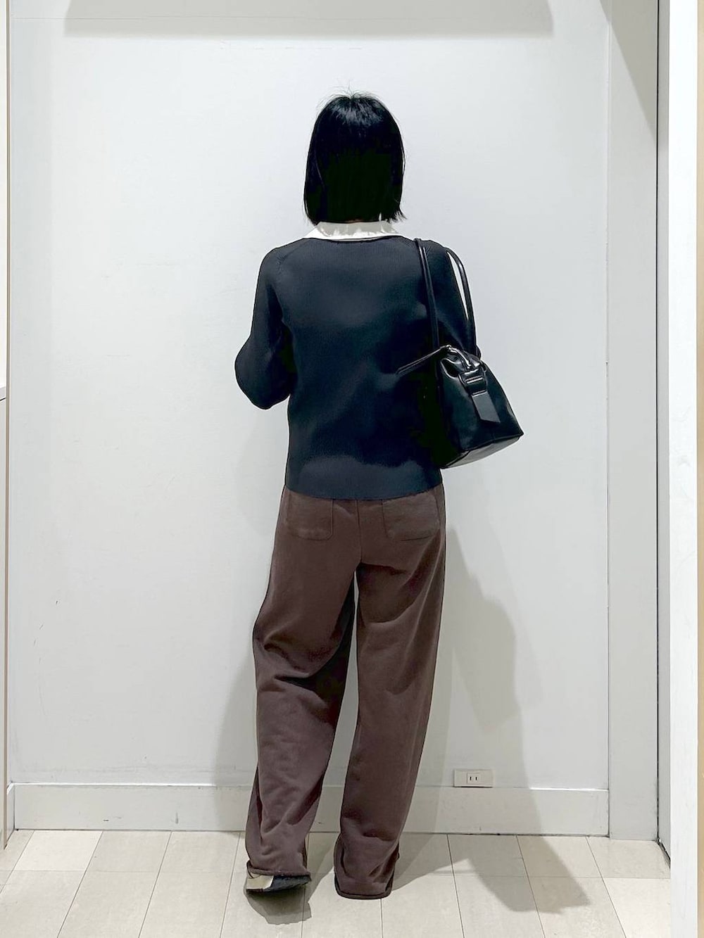 ブラック系のボストンバッグ、グレー系のニット/セーター、ブラウン系のスウェットパンツを着用したレディースの冬コーディネートの3枚目の写真