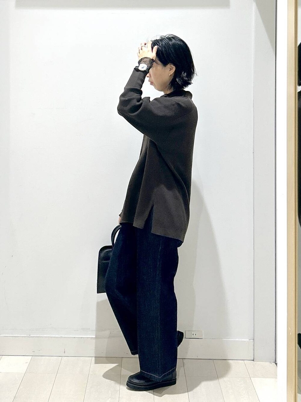 ブラック系のローファー、ブルー系のデニムパンツ、ブラック系のショルダーバッグを着用したレディースの秋コーディネートの4枚目の写真