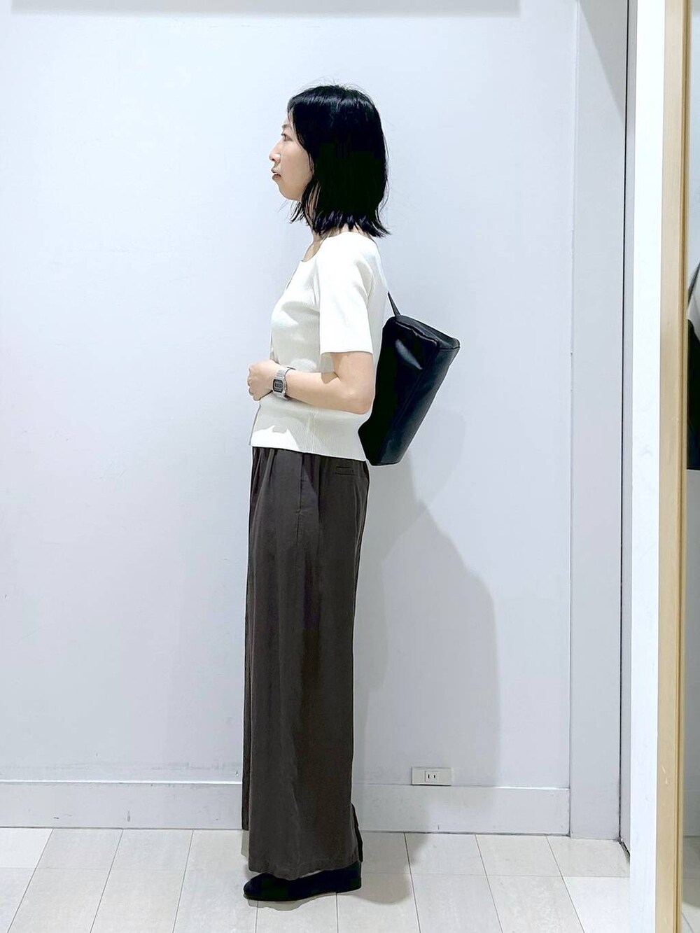 ブラック系のローファー、ブラウン系のその他パンツ、ブラック系のショルダーバッグを着用したレディースの春コーディネートの2枚目の写真