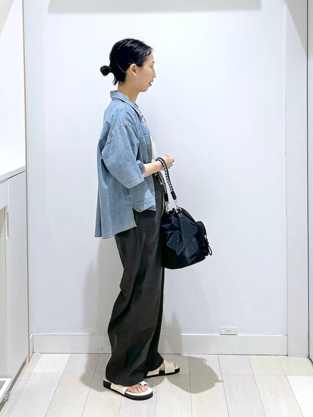 ブラック系のショルダーバッグ、ホワイト系のTシャツ/カットソー、ブルー系のシャツ/ブラウスを着用したレディースの夏コーディネートの4枚目の写真