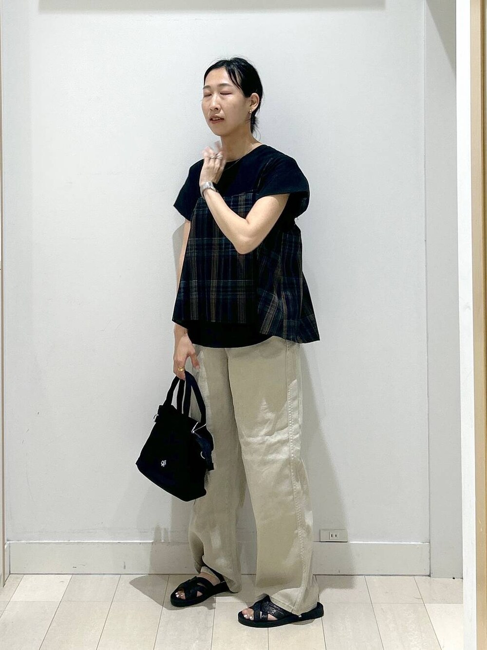 ブラック系のトートバッグ、ブラック系のサンダル、ブラック系のTシャツ/カットソーを着用したレディースの夏コーディネートの4枚目の写真