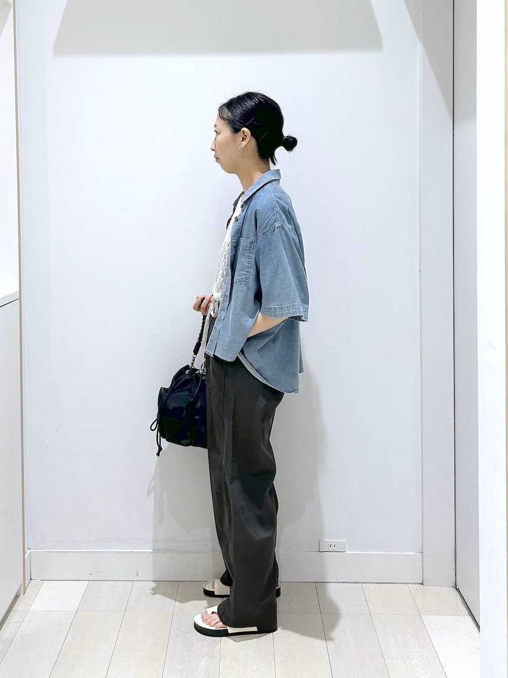 ブラック系のショルダーバッグ、ホワイト系のTシャツ/カットソー、ブルー系のシャツ/ブラウスを着用したレディースの夏コーディネートの2枚目の写真