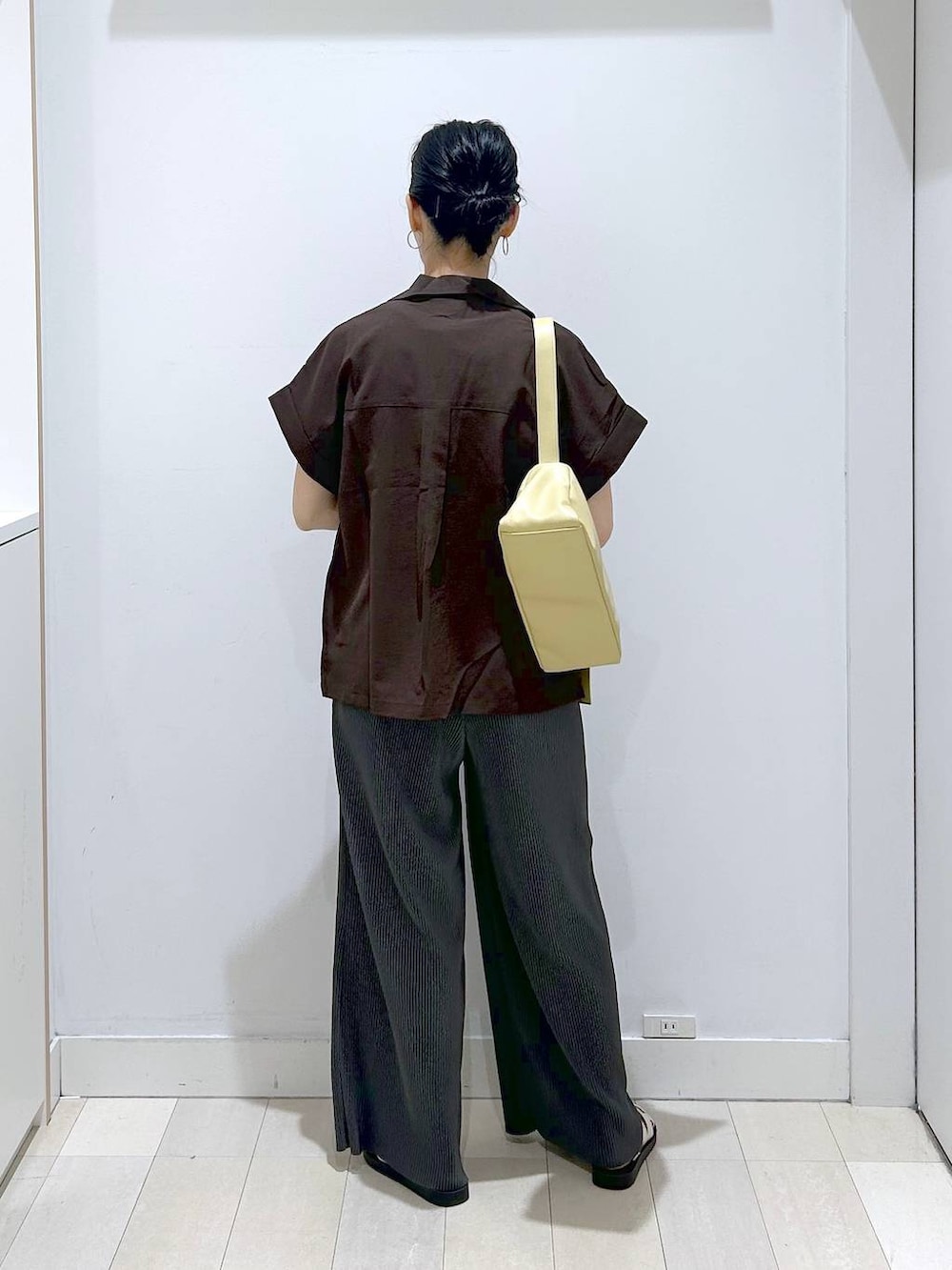 イエロー系のショルダーバッグ、ホワイト系のタンクトップ、ブラック系のその他パンツを着用したレディースの夏コーディネートの3枚目の写真