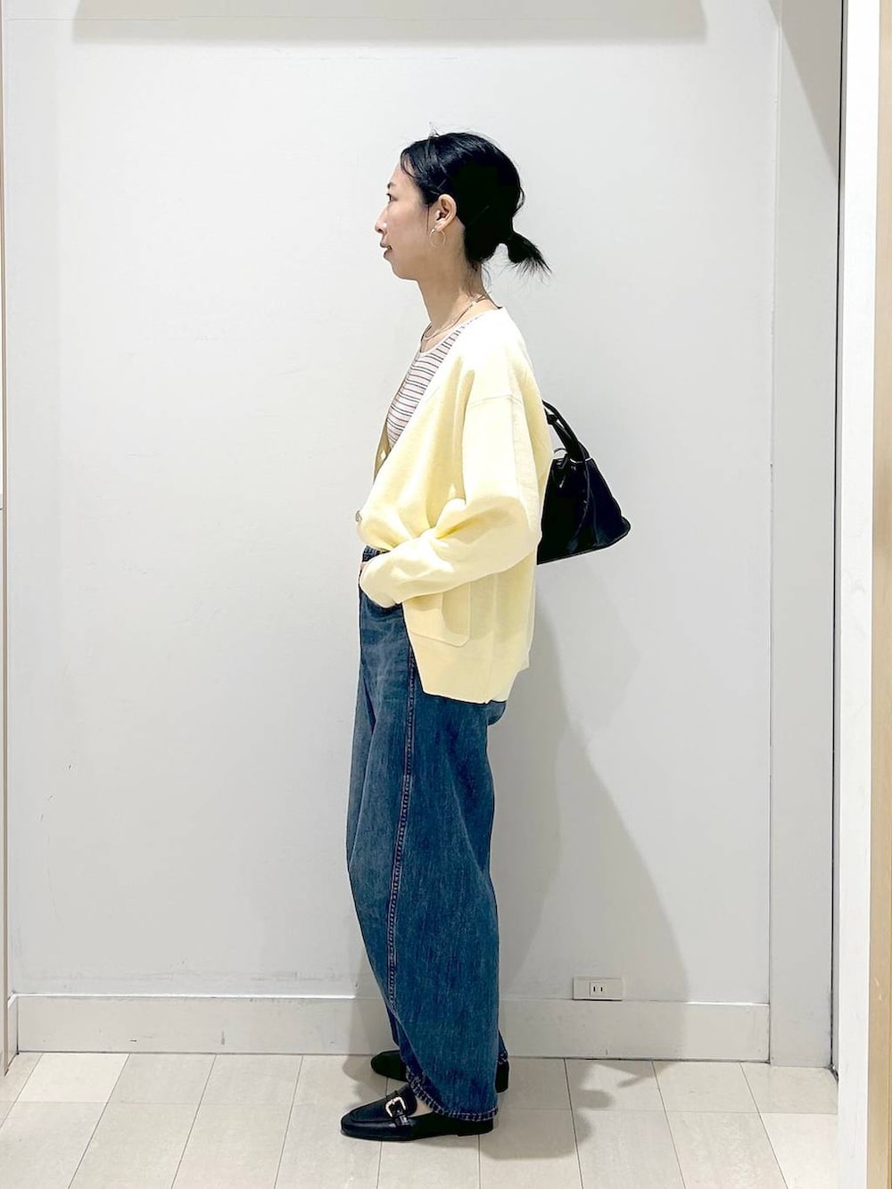 ブラック系のローファー、ブルー系のデニムパンツ、イエロー系のカーディガン/ボレロを着用したレディースの春コーディネートの2枚目の写真