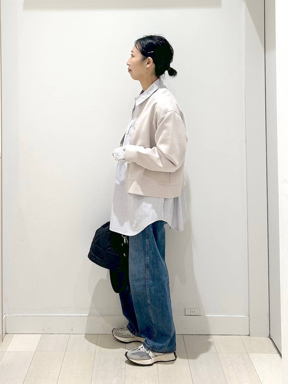 ブラック系のハンドバッグ、ブルー系のデニムパンツ、ピンク系のカーディガン/ボレロを着用したレディースの春コーディネートの4枚目の写真