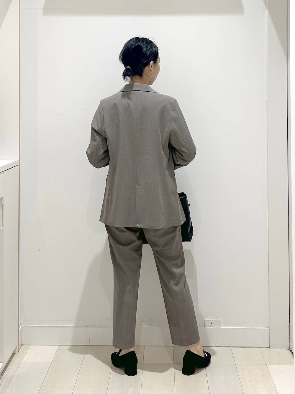 ブラック系のローファー、ブラウン系のスラックス、ホワイト系のシャツ/ブラウスを着用したレディースの春コーディネートの3枚目の写真