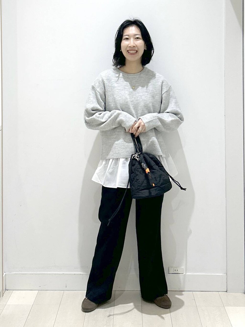 ブラック系のハンドバッグ、シルバー系のニット/セーター、ブラック系のその他パンツを着用したレディースの冬コーディネートの5枚目の写真