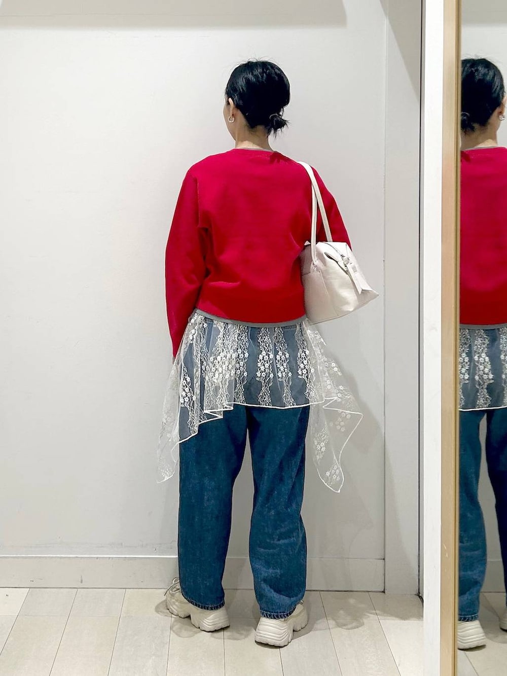 ホワイト系のボストンバッグ、ブルー系のデニムパンツ、ホワイト系のその他トップスを着用したレディースの春コーディネートの3枚目の写真